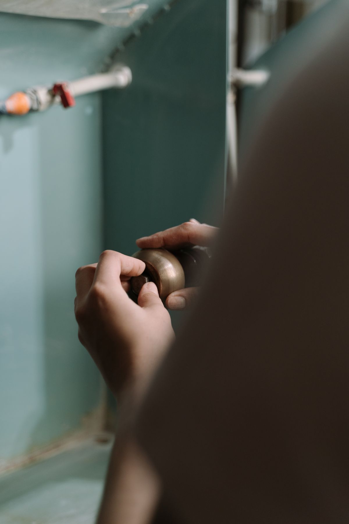 Hands adjusting a pipe fitting during plumbing work